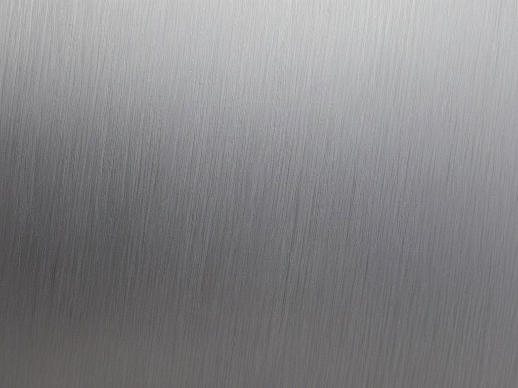 Close-up of a brushed stainless steel surface with a shallow dent