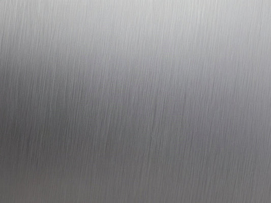 Close-up of a brushed stainless steel surface with a shallow dent
