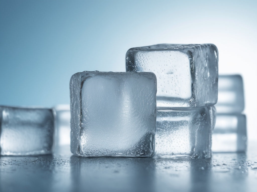 Large clear ice cubes with water droplets on a cool blue background