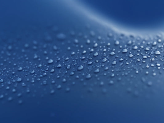 Macro of a deep blue silicone surface with water droplets