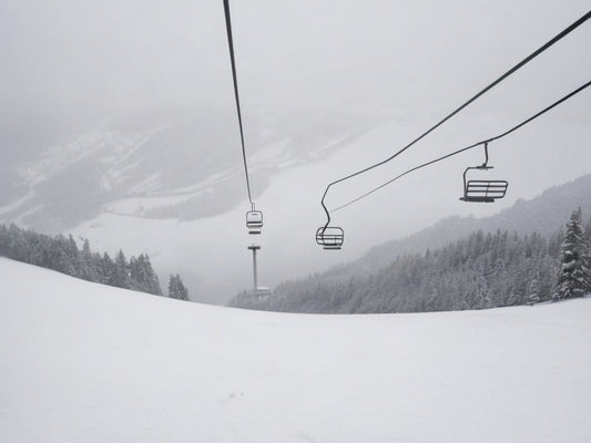 Empty ski lift chairs on a snowy mountain slope