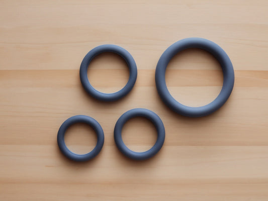 Plain silicone hand grip resistance rings on a wooden desk