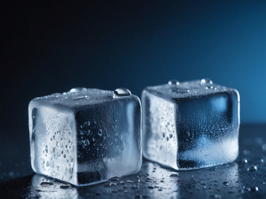 Close-up of clear ice cubes with condensation on a dark surface