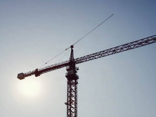 Tower crane boom against a bright sky