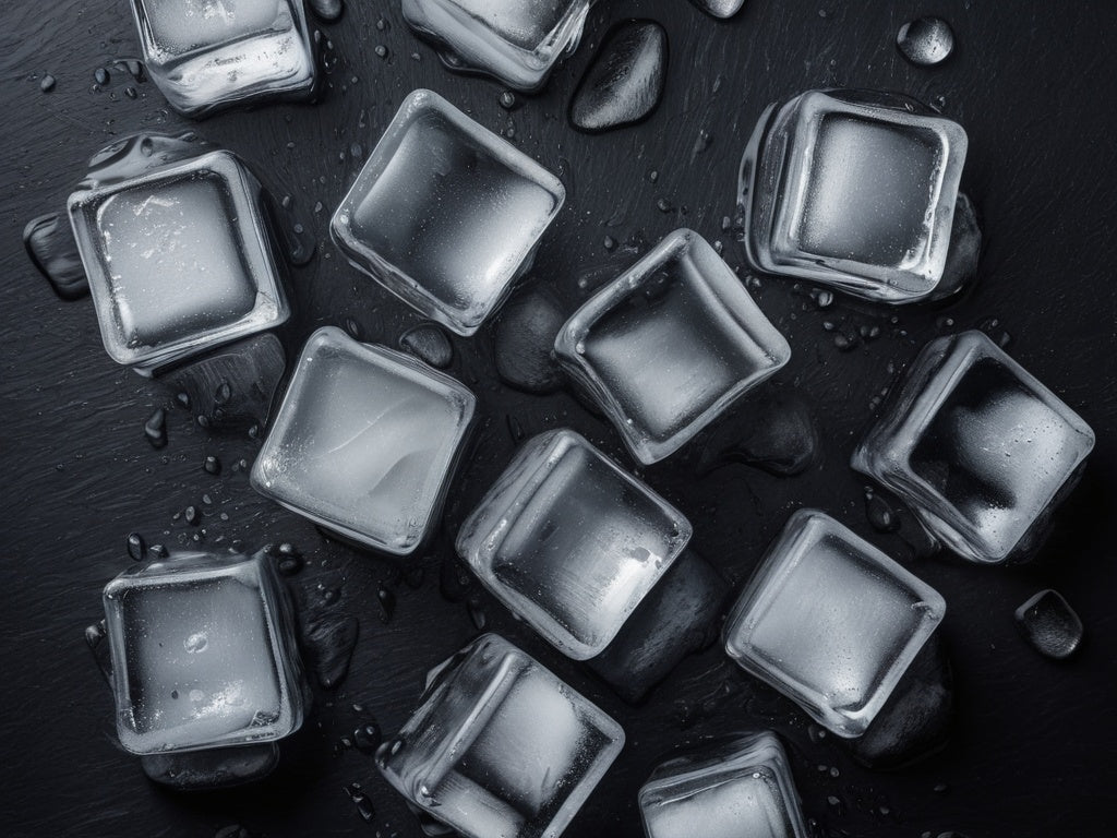 Fresh ice cubes flat-lay on a dark slate surface