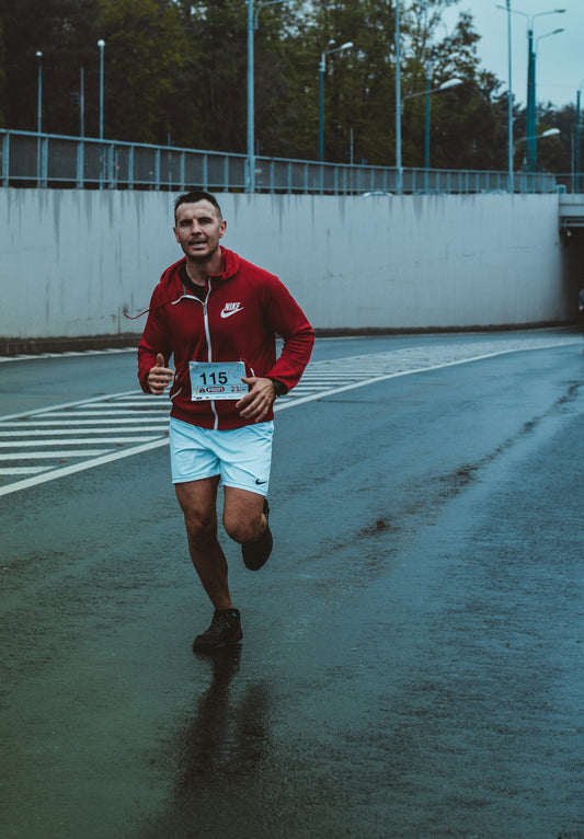 Man running outdoors on a sunny day, working up a sweat